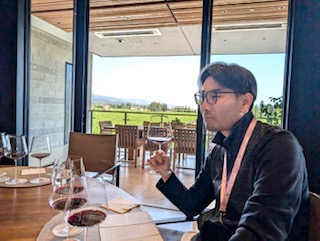 窓の奥のブドウ園を眺めながらの試飲